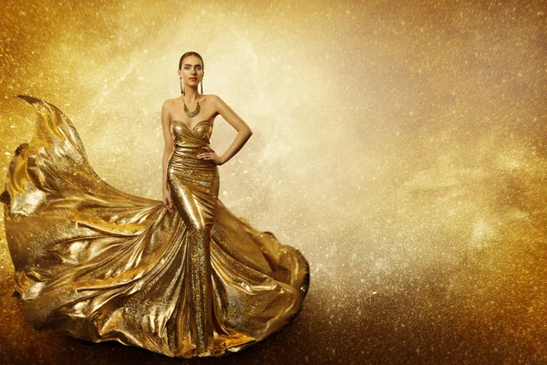 Modelo de moda dourada, mulher elegante em vestido de ouro, acenando com vestido espumante — Fotografia de Stock