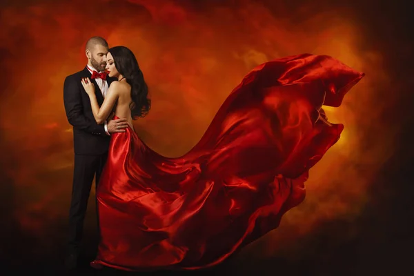 Elegáns pár, táncoló nő piros ruha csapkodott repül a szél és a Man in Black Suit, szeretet-portré — Stock Fotó