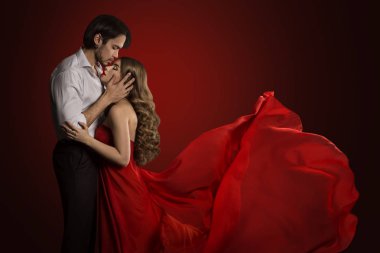 Çift öpüşme, genç adam öpücük kadın, kırmızı elbise sallayarak kumaş, romantik aşk