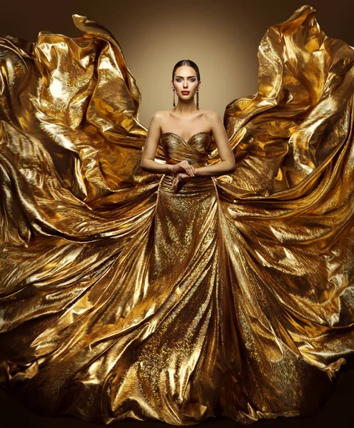 Vestido de voo de mulher de ouro, Modelo de moda em acenar vestido dourado, Tecido Fluttering, Retrato de beleza de arte — Fotografia de Stock