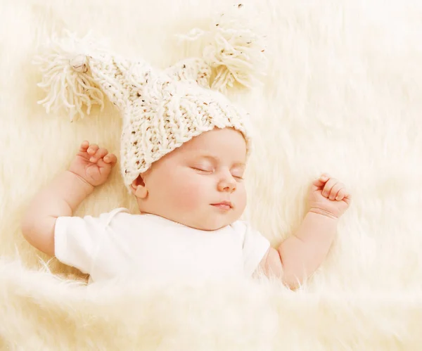 Bebé dormido, niño recién nacido con sombrero de lana durmiendo en manta de piel blanca —  Fotos de Stock