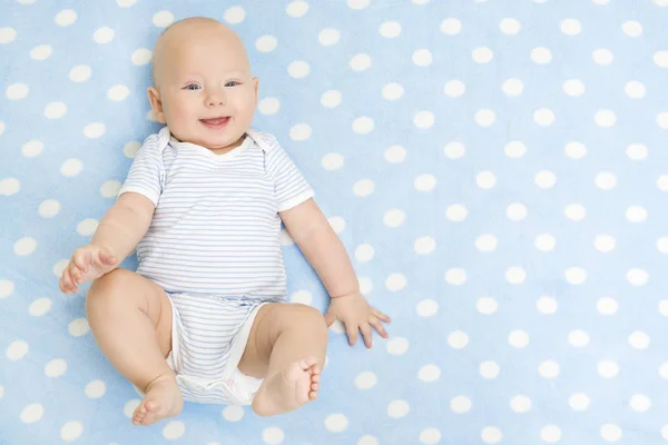 Happy Baby leží na modrém koberci pozadí, pohled shora, usmívající se dítě Kid Boy v kombinézu na dece — Stock fotografie