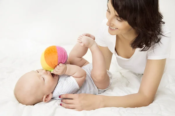 Мать и ребенок играют в игрушечный мяч, новорожденный ребенок играть с мамой, счастливая семья — стоковое фото