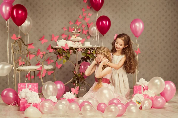 День рождения детей, закрывающие глаза девочки, украшенные ретро-подарки и воздушные шары — стоковое фото