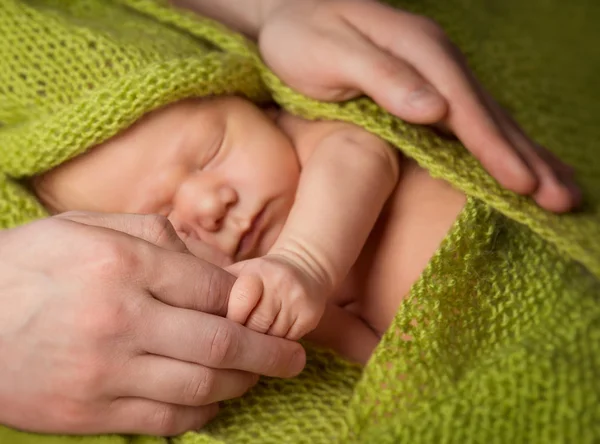 Bebê recém-nascido dormindo em mãos paternas, protegendo o recém-nascido — Fotografia de Stock