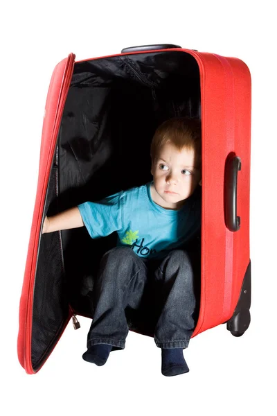 Enfant assis dans une valise rouge, enfant jouant avec de gros bagages, isolé sur fond blanc — Photo