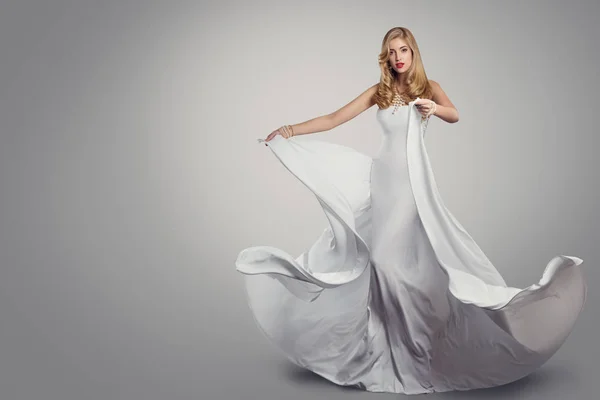 Женщина танцует длинное белое шелковое платье, модель моды размахивая платьем — стоковое фото