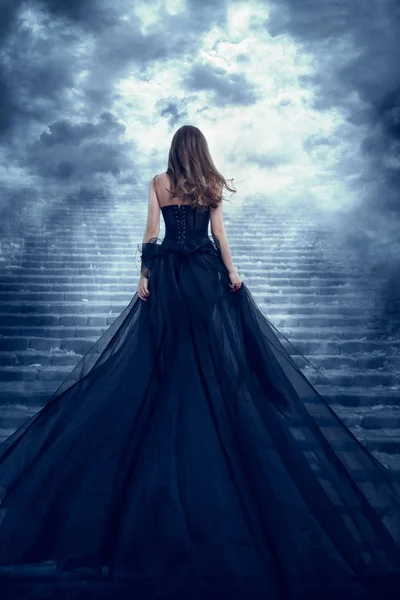 Mulher de vestido comprido Visão traseira Escalada Escadas de pedra para o céu — Fotografia de Stock