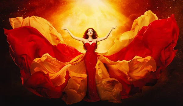 Femme en robe volante levé les bras à la lumière, robe rouge — Photo