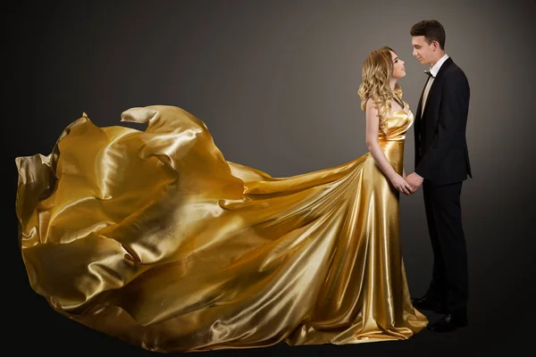 Pár, Gyönyörű nő arany selyem ruha és elegáns férfi — Stock Fotó
