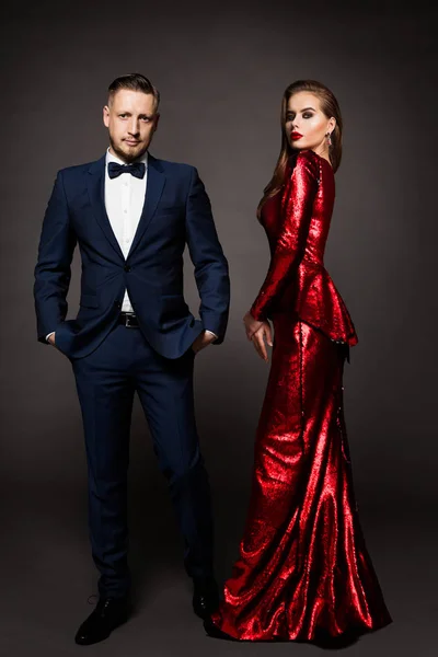 Casal de luxo, bela mulher de moda em vestido vermelho, homem elegante — Fotografia de Stock