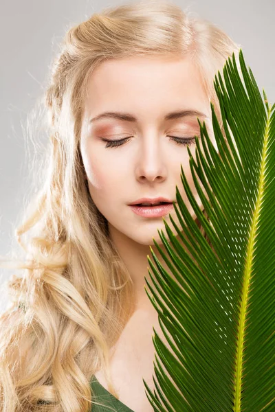 女性と新鮮なエキゾチックなヤシの葉 顔の毛の治療 若いモデルの美しさの肖像自然を構成する — ストック写真