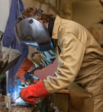 Sculptor welding metal piece clipart