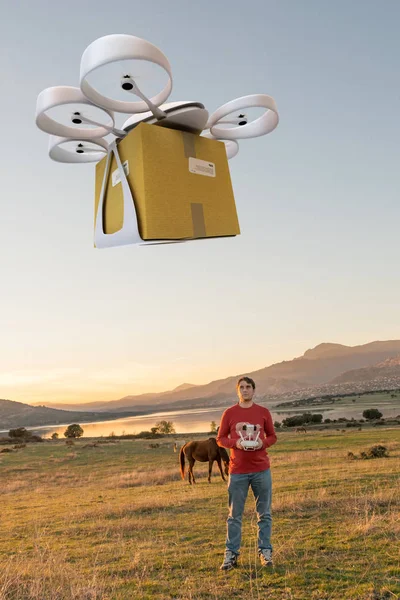 Uomo che guida un drone con un pacco — Foto Stock