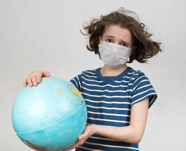 戴着医疗面具的少女举着全球 — 图库照片#
