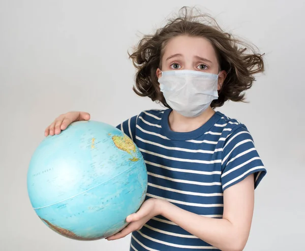戴着医疗面具的少女举着全球 — 图库照片#
