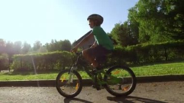 Genç çocuk bir kask içinde Bisiklete binmek 