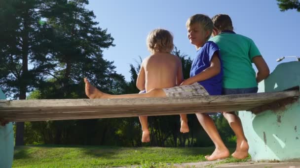 Дети сидят на скамейке и играют вместе . — стоковое видео