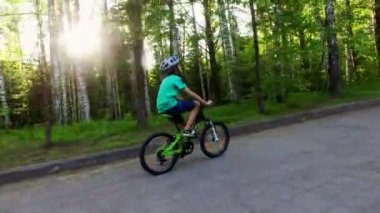 Genç çocuk yolda bir kask içinde bir Bisiklete binmek