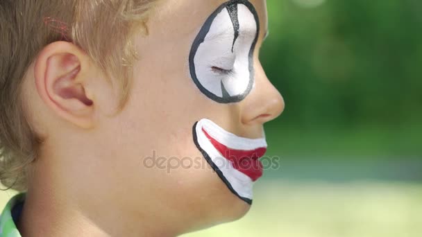 Професійний художник застосовує макіяж клоуна на обличчі дитини — стокове відео