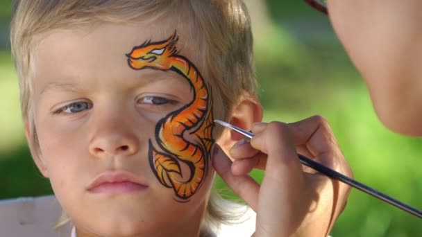 Målning draken mönster på ett ansikte av en pojke — Stockvideo
