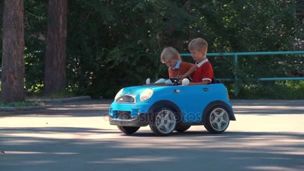Маленькие мальчики за рулем игрушечного ретро автомобиля — стоковое видео