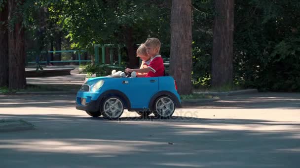 Діти за кермом іграшкового ретро-автомобіля в парку і зупинилися . — стокове відео