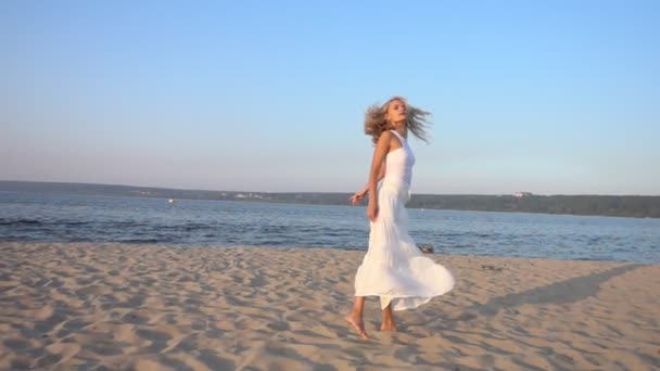 Mujer en vestido blanco bailando en la playa — Vídeos de Stock