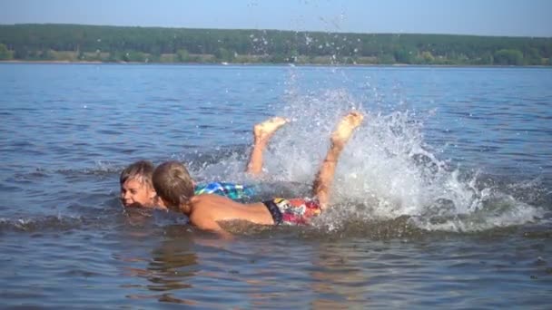 Niños divirtiéndose en el mar en cámara lenta — Vídeos de Stock
