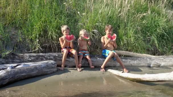 Tři děti jíst meloun venku — Stock video
