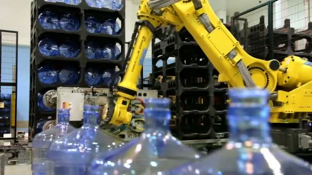 Robots laders werken in een magazijn. Waterfles transportband industrie. — Stockvideo