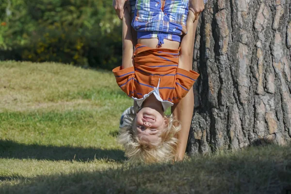 happy kid playing upside down outdoors