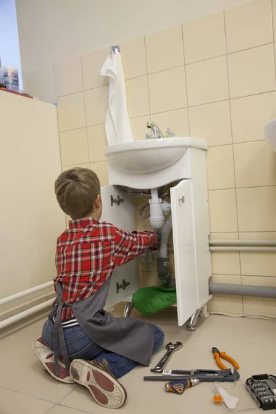 Хлопчик ремонтує сантехніку в раковині — стокове фото