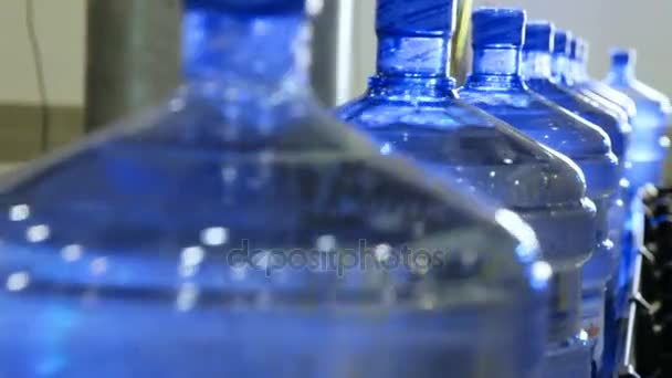 Grandes botellas de agua pura moviéndose en la cinta transportadora — Vídeos de Stock