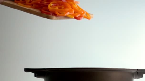 Нарезанный перец падает с доски в кастрюлю — стоковое видео