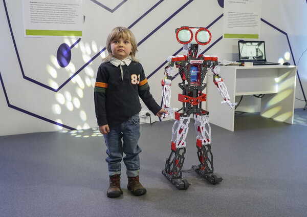  Маленький мальчик, стоящий с роботом и держащийся за руки
 