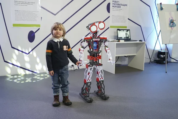 Маленький мальчик взаимодействует с умным роботом — стоковое фото