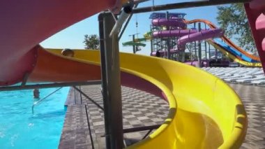 Genç çocuk aqua park açık, büyük renkli su slayttan kayar 