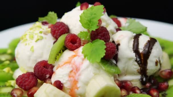 Vanilla ice cream scoops with fresh raspberries, banana and kiwi slices — Stock Video