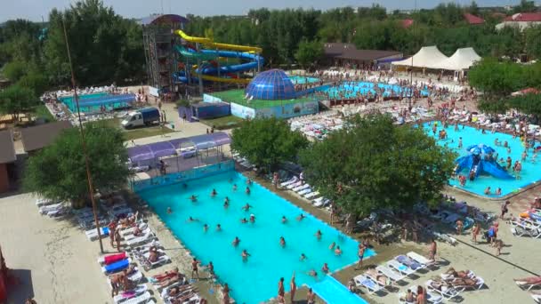 Mensen ontspannen, zwemmen in het buitenzwembad in groot aquapark — Stockvideo