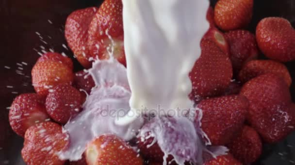 Выливание молока на клубнику в замедленной съемке — стоковое видео