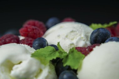 Yaban mersini ve çilek ile dondurma yakın çekim siyah arka plan üzerine