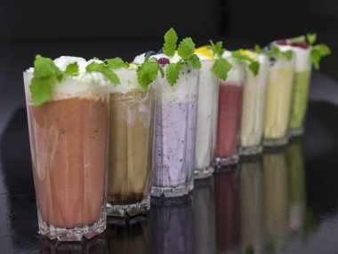 Satır ile dondurma, meyve ve çilek siyah arka plan üzerine lezzetli milkshakes