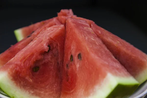 Slice of watermelon close up on black background