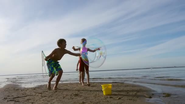 Gelukkige Kinderen Buiten Blazen Van Zeepbellen Het Strand — Stockvideo