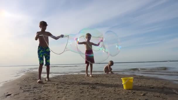 Três Meninos Felizes Brincando Com Grandes Bolhas Sabão Praia Mar — Vídeo de Stock