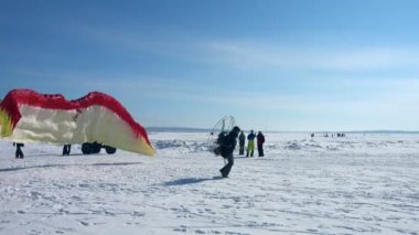 Novosibirsk, Rusya - 10 Mart 2018: Ob nehir Festivali motorlu yamaç paraşütü ppg: adam çıkartıyor Yamaçparaşütü üzerinde bir motor ile güneşli kış günü