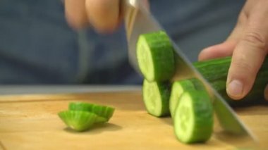 Şef Aşçı kesme taze salatalık ahşap tahta üzerinde eller closeup