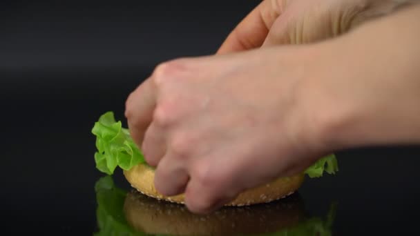 Женщина Делает Вегетарианский Сэндвич Помидорами Сыром Луком Салатом Черном Фоне — стоковое видео