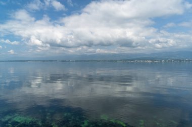 Göl suyu gökyüzü bulutlarını yansıtır. Cenevre Gölü Lac Leman, İsviçre